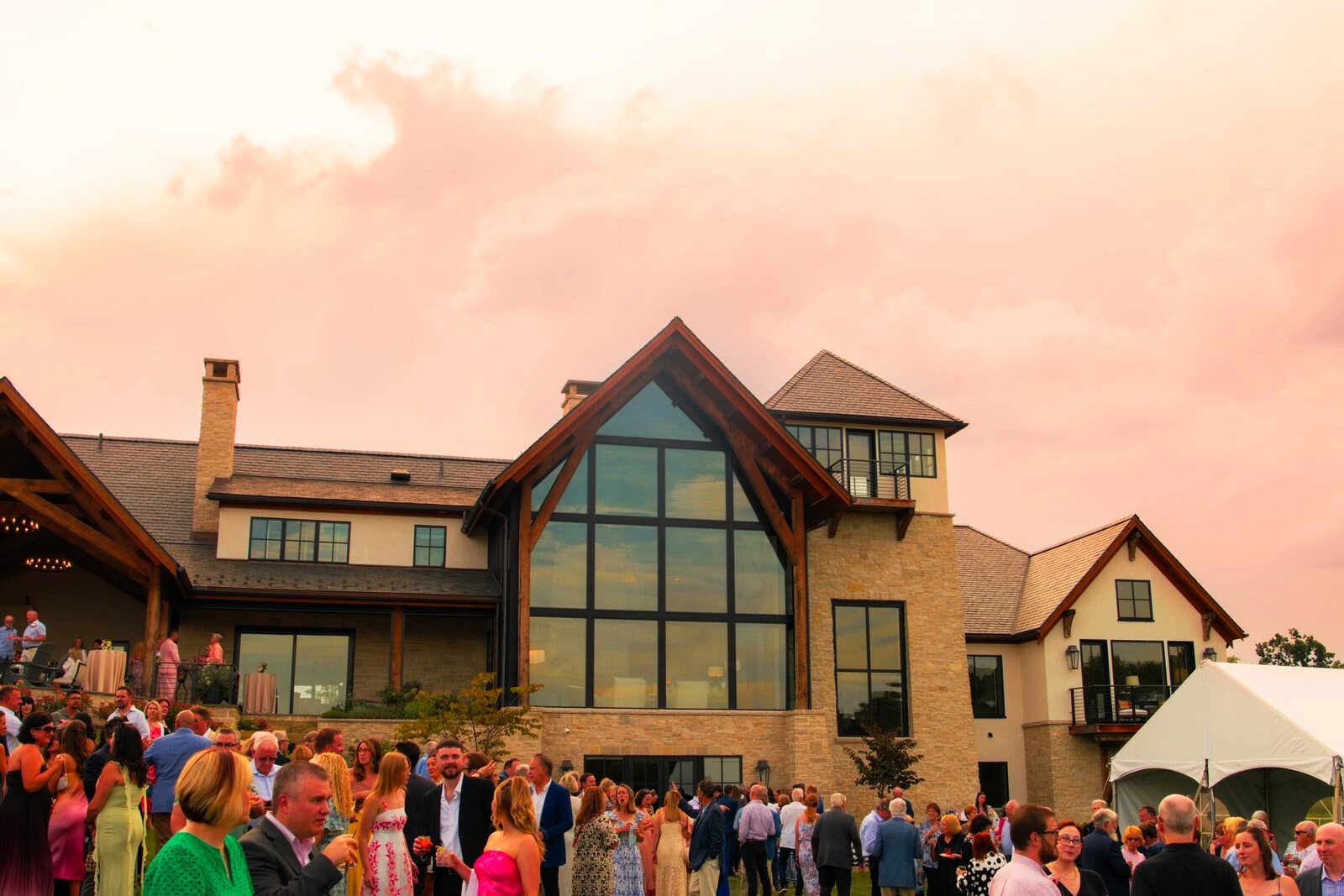Outdoor event venue at golden hour with tables and umbrellas.