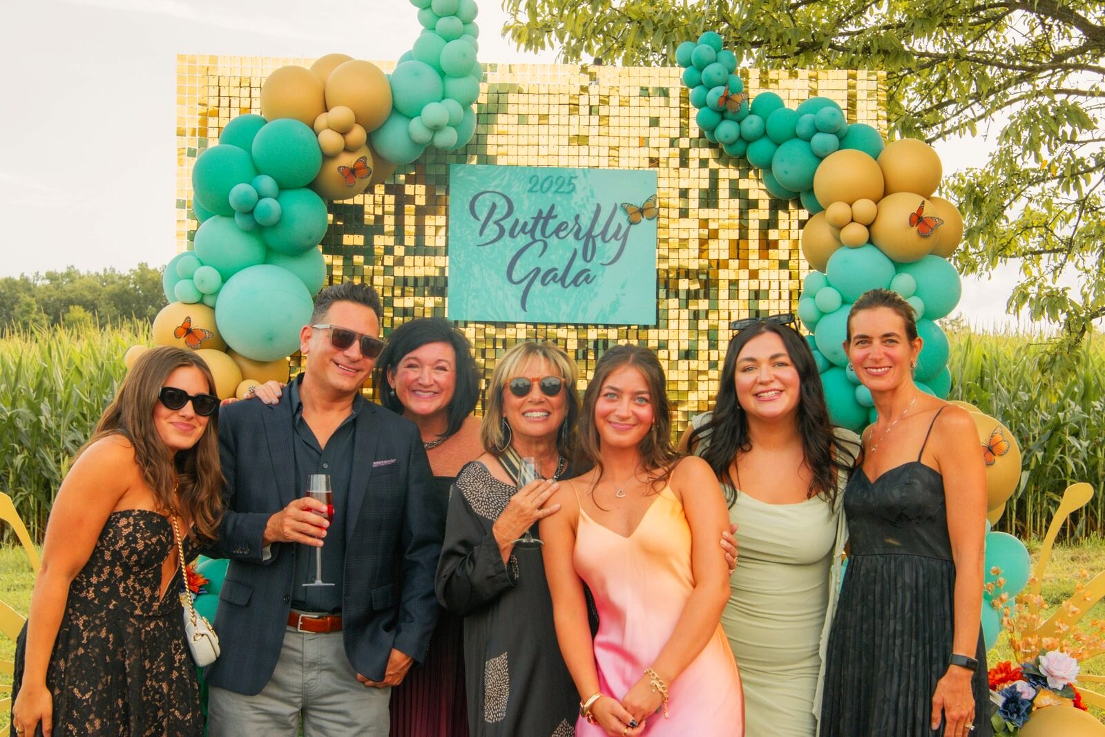 Group of guests gathered at the Butterfly Gala backdrop.
