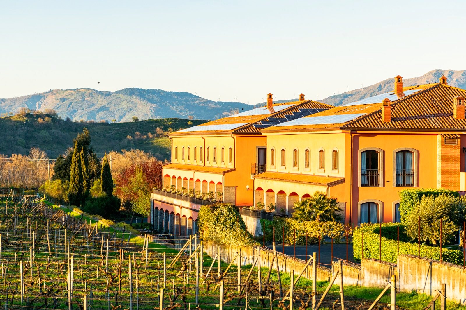 Sicilian wine country with a villa on a green hillside.