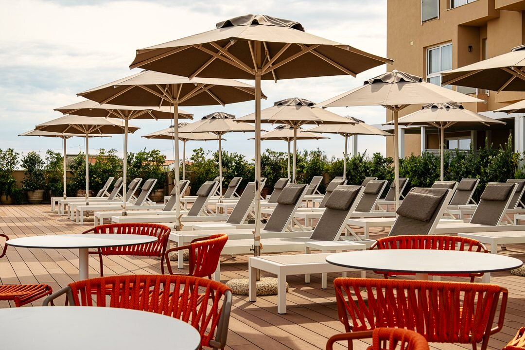 Pool terrace with umbrellas before guests arrive.