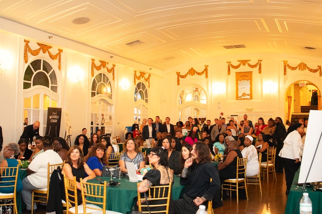 Full ballroom of seated guests during a gala program.