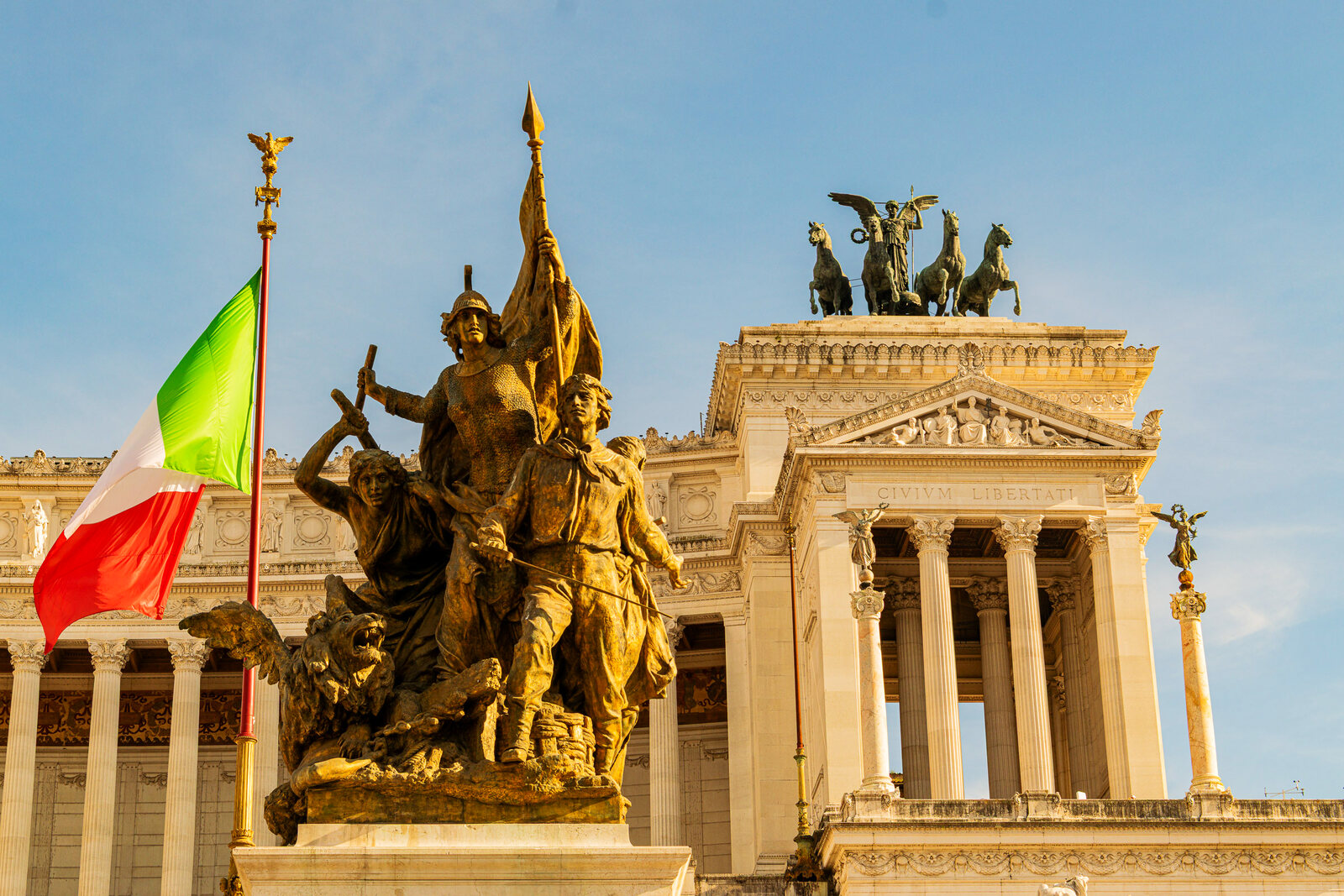 Gilded statuary atop Rome's Vittoriano monument in warm light.