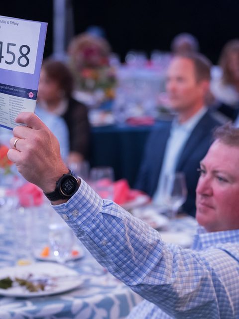 A guest raises bid paddle 458 during the paddle raise, cropped for Instagram.