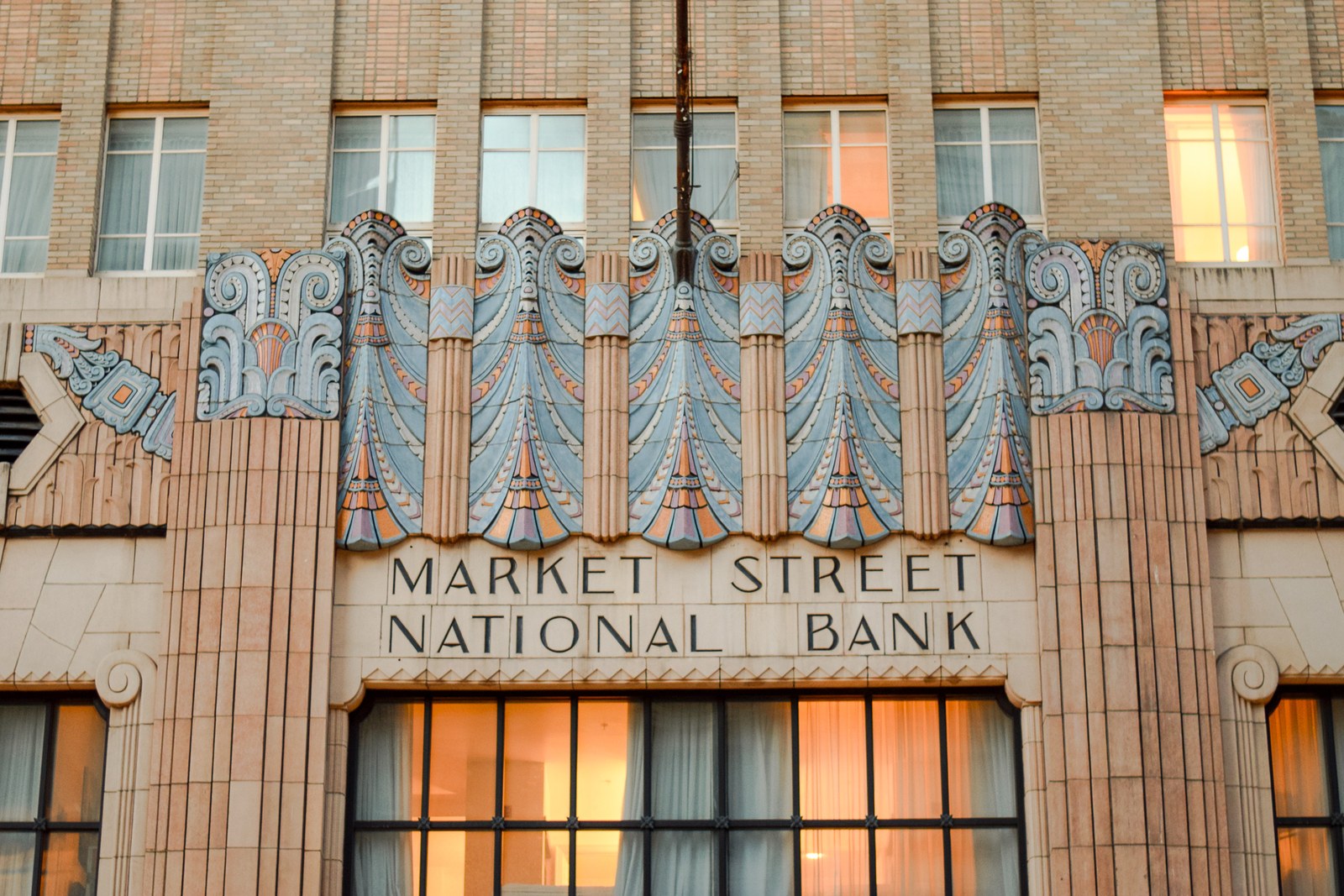 Ornate art deco terracotta details above the entrance of the Market Street National Bank building.